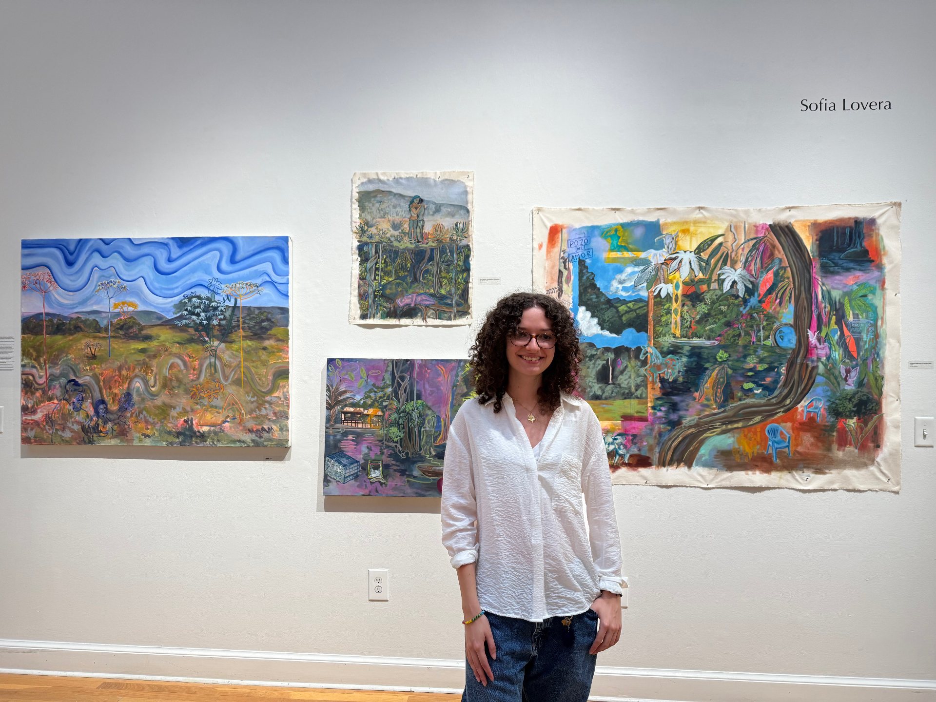 Sofia Lovera standing in front of her BFA thesis paintings